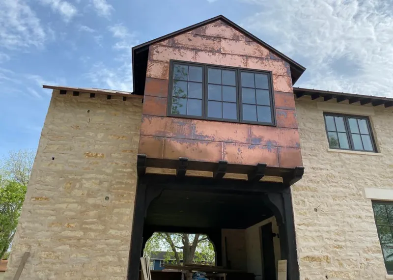 Copper metal panel facade on a stone building for Skylight Installation in Superior